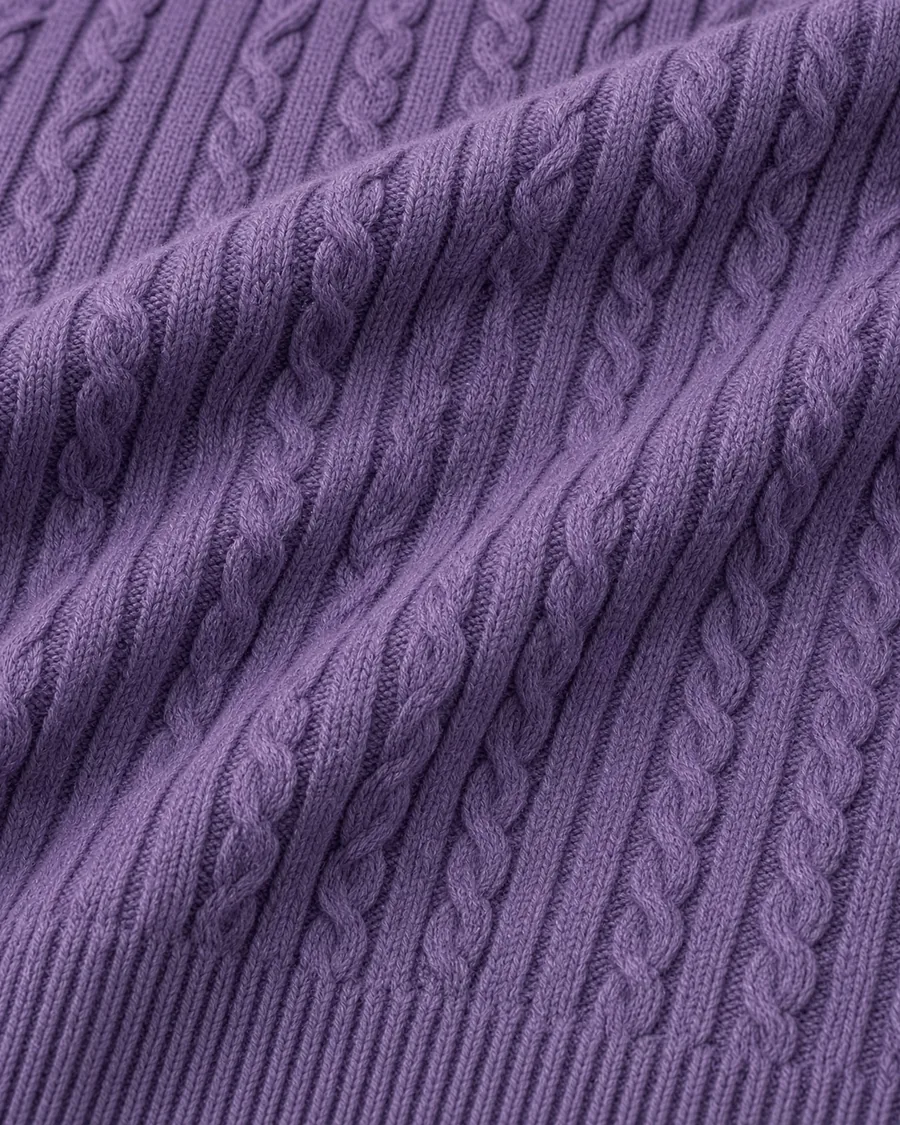 Malha do suéter Trança roxo de perto, em drapeado sobre fundo claro.
