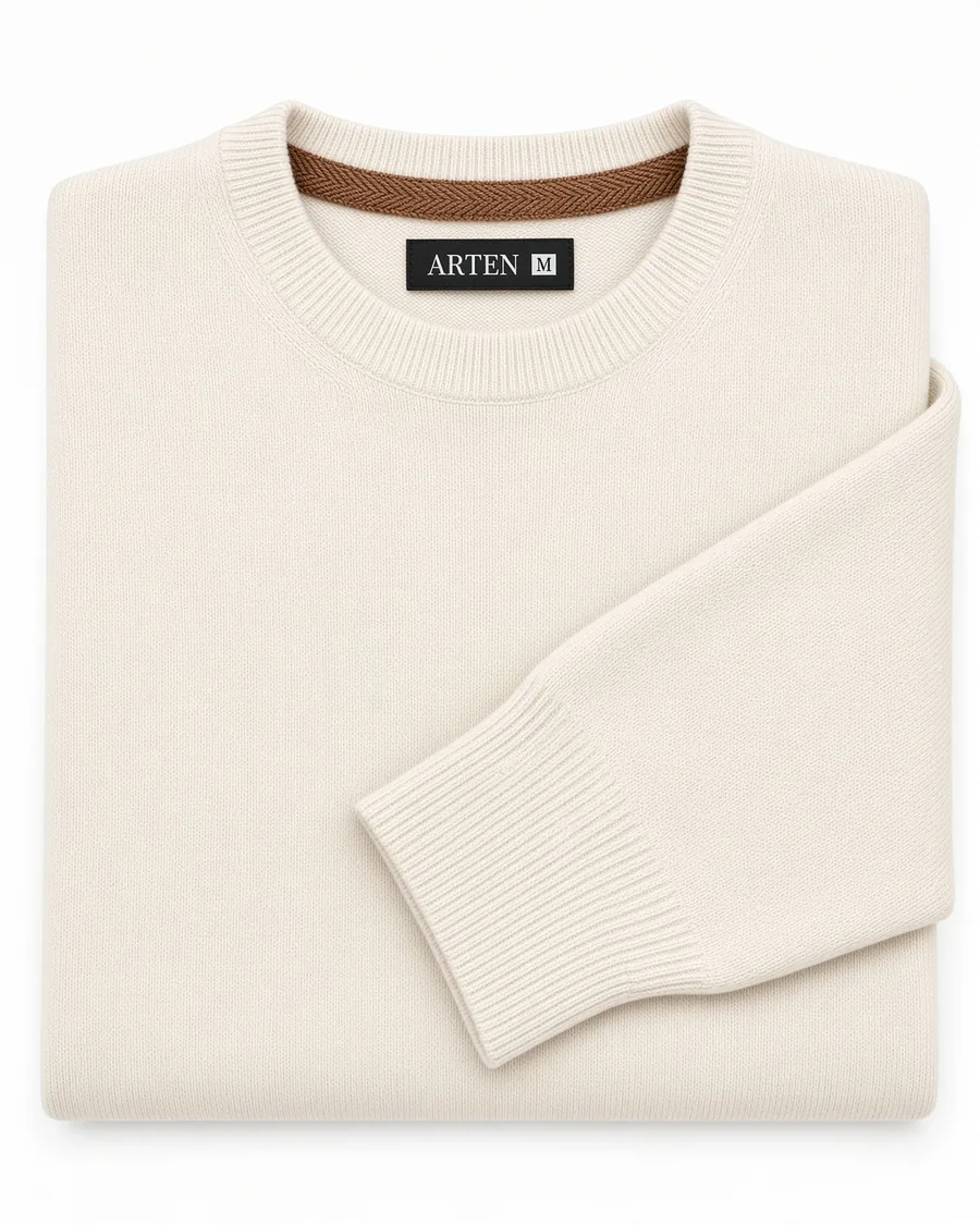 suéter Liso off-white, dobrado sobre fundo claro.